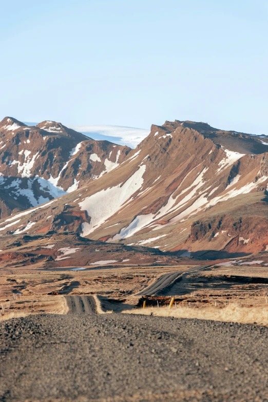 snowy mountains behind the desert with a dirt road