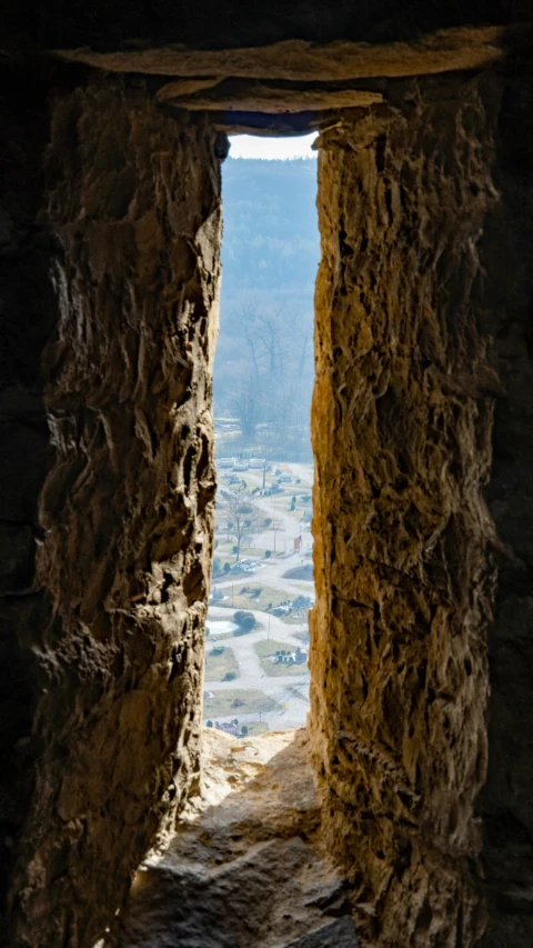 looking out over the town from a tunnel in a rock wall