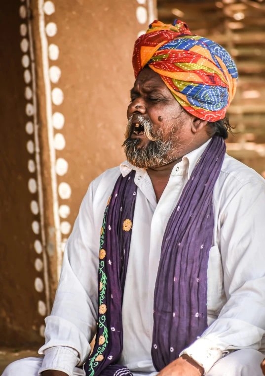 a man wearing a turban sitting down