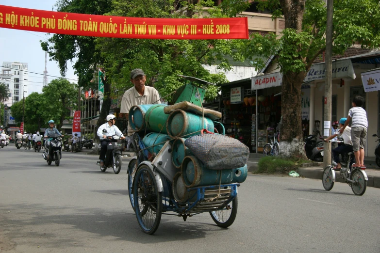 a man is carrying several sacks and bags on a bike