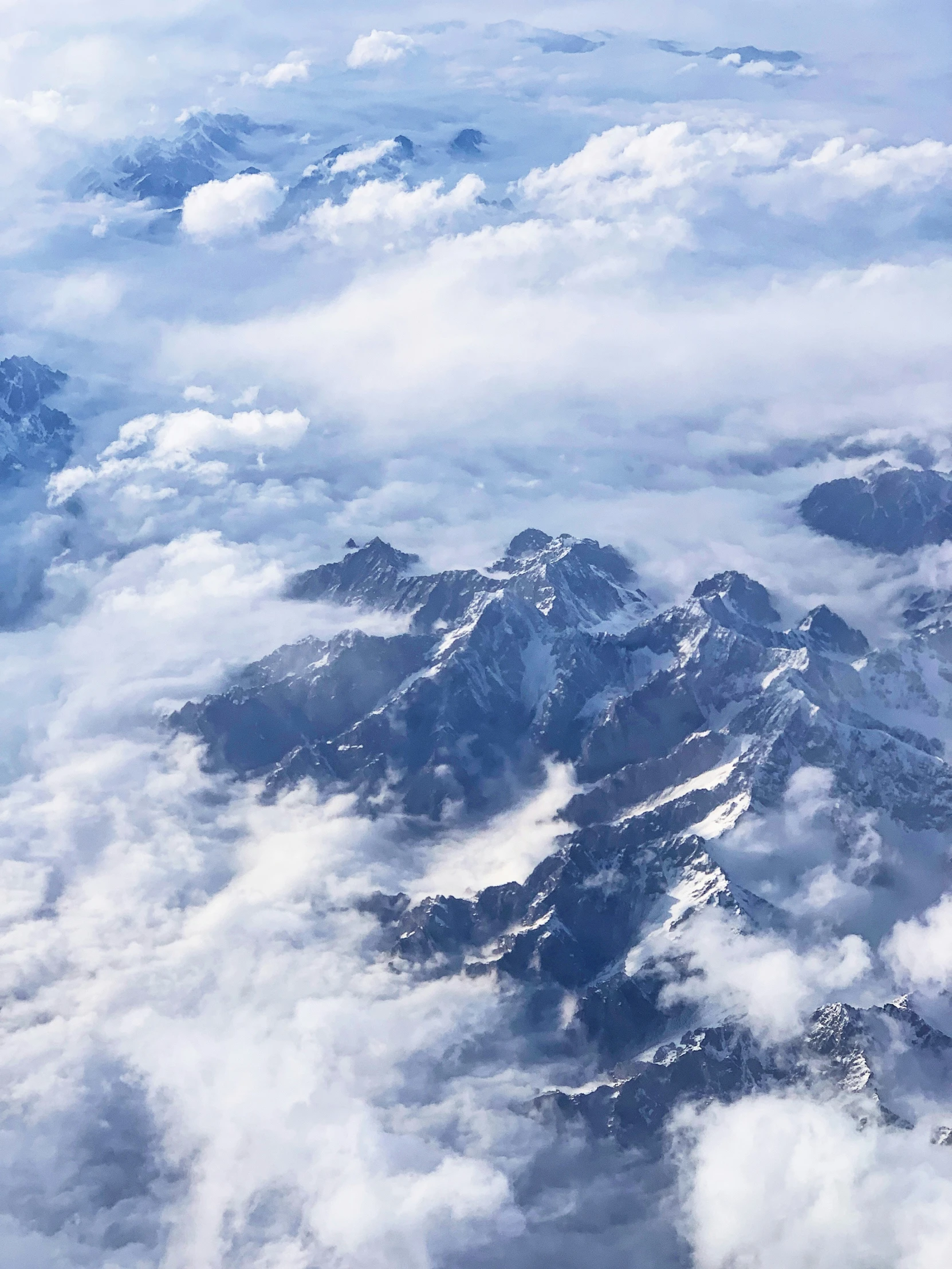 the view from an airplane of some snowy mountains