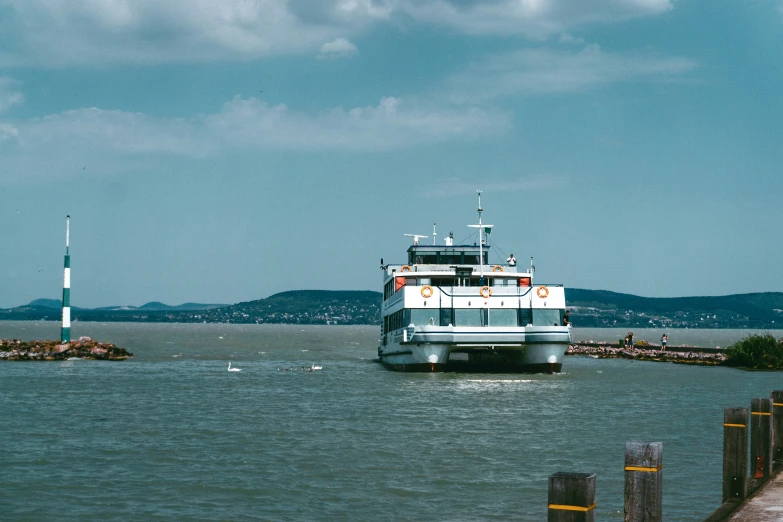 a boat sails out to sea off of a pier