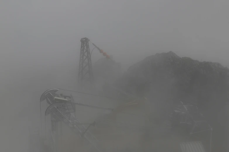 the tower crane is surrounded by fog and rock