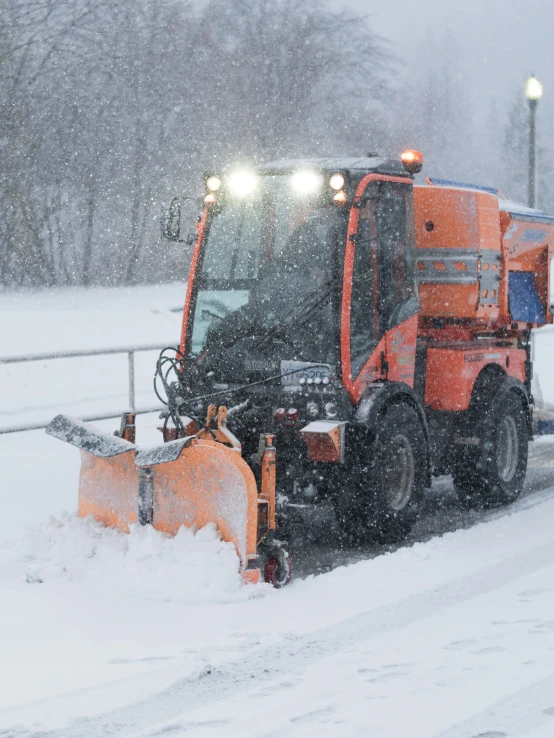 the truck is plowing snow from the road