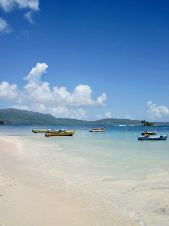 a group of boats floating on top of a beach