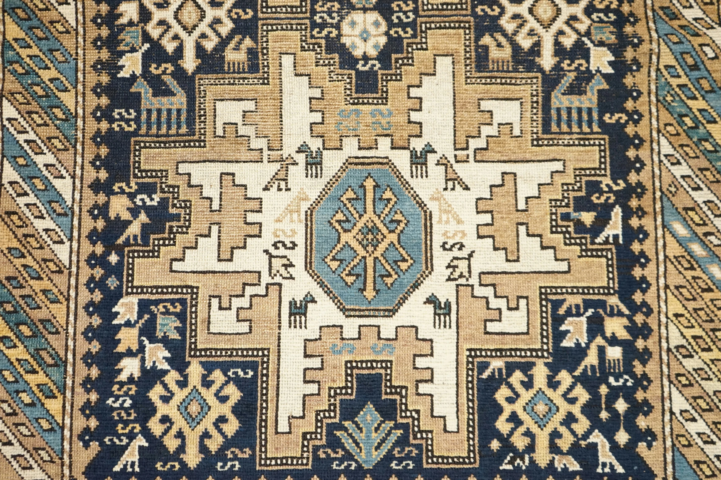 an oriental rug with various designs in blue, beige and yellow