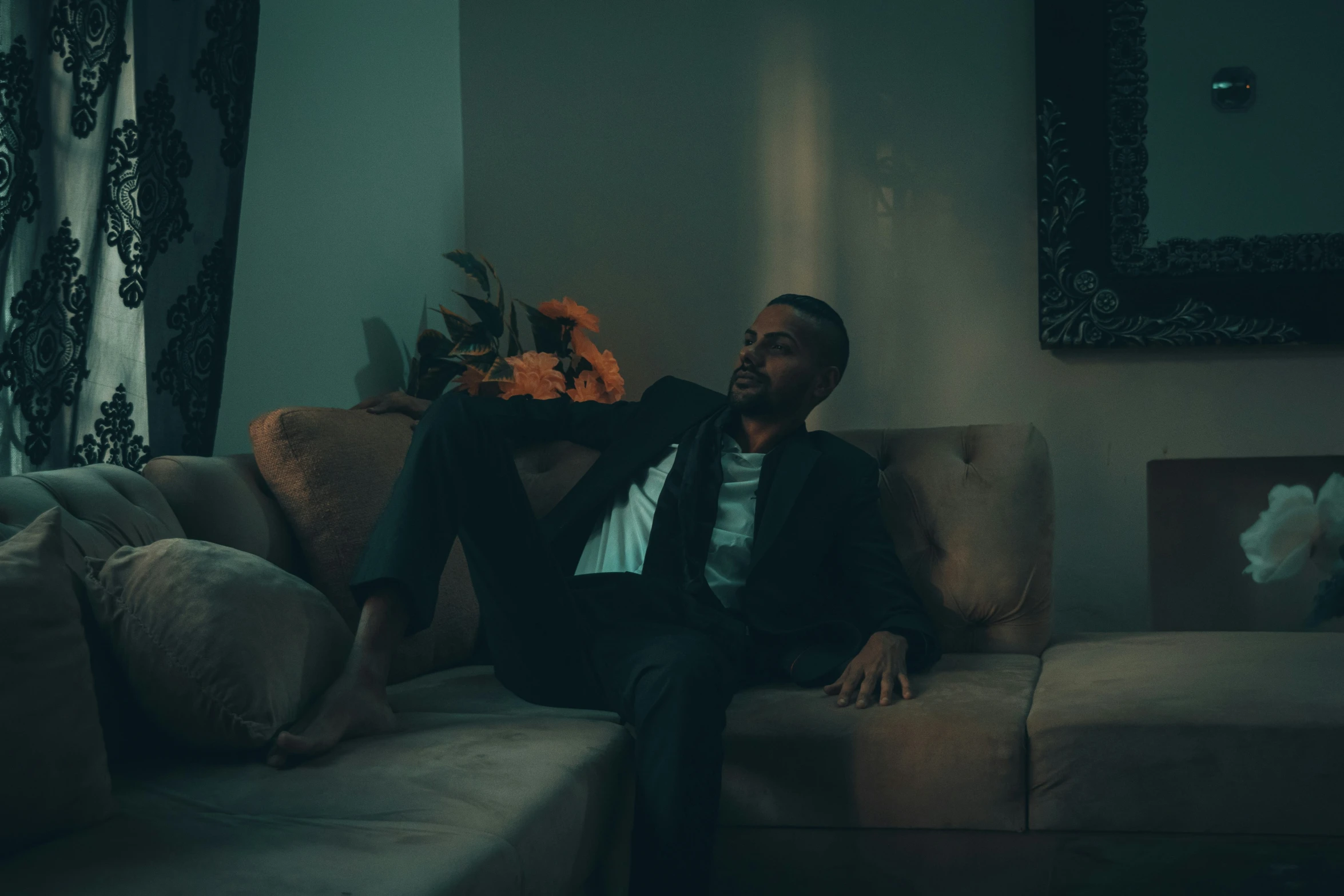 a man sitting on a couch in a dimly lit room