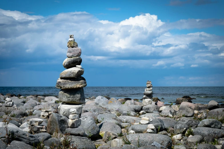 the stack of rocks is standing on each other by the ocean