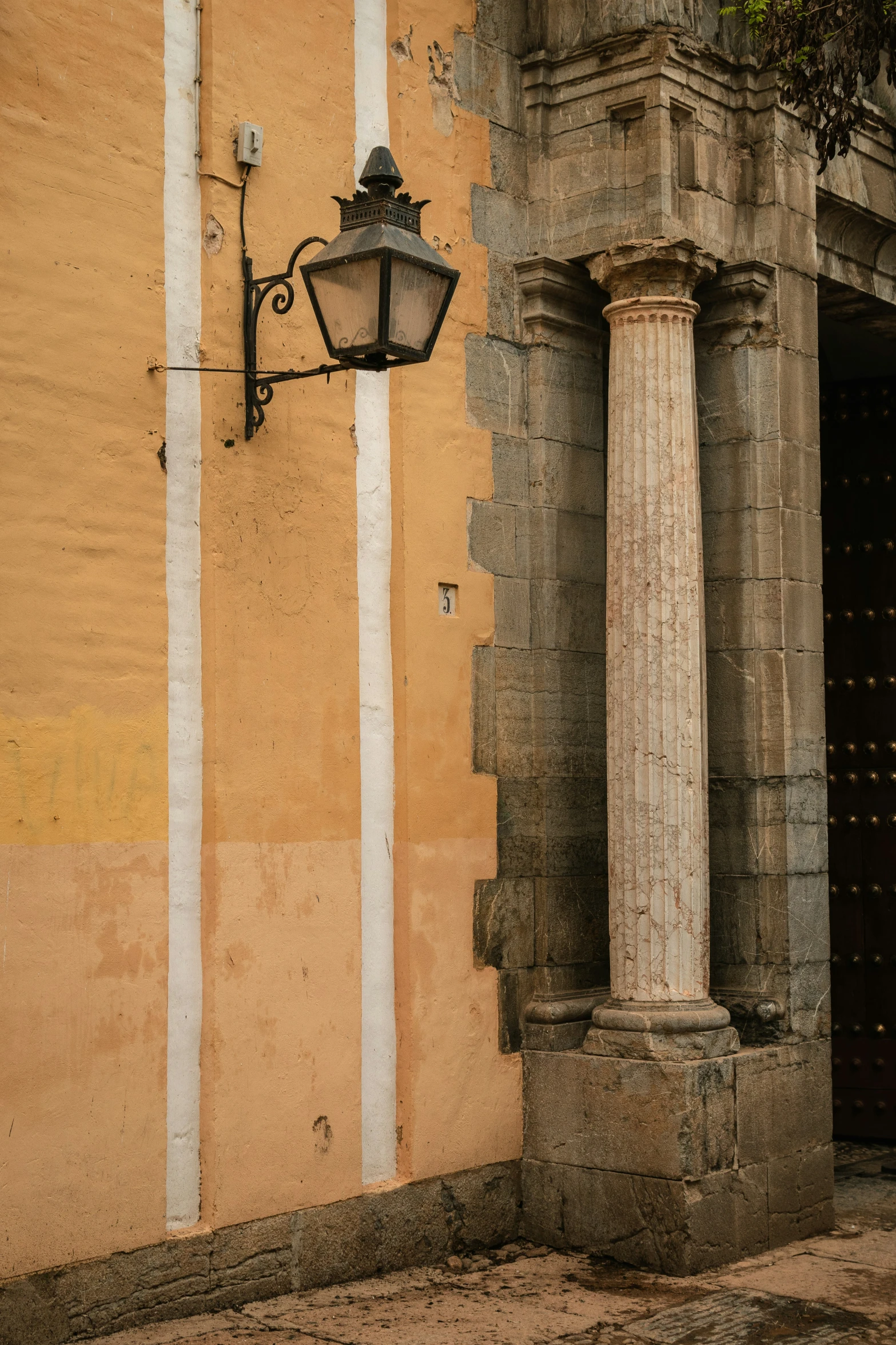 an old building with columns and a lamp on it