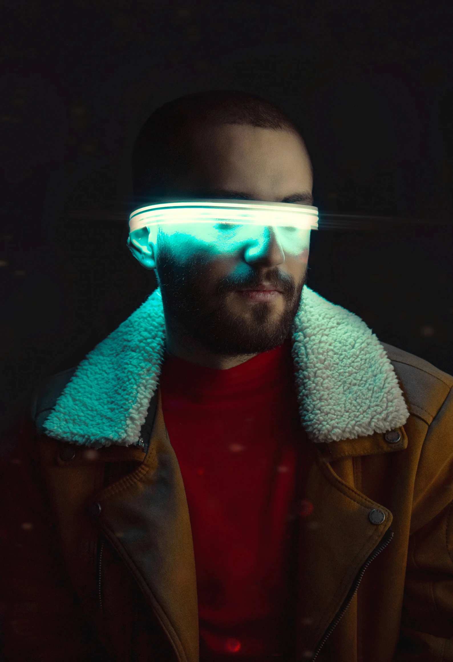 a man with a hat and glasses in the dark