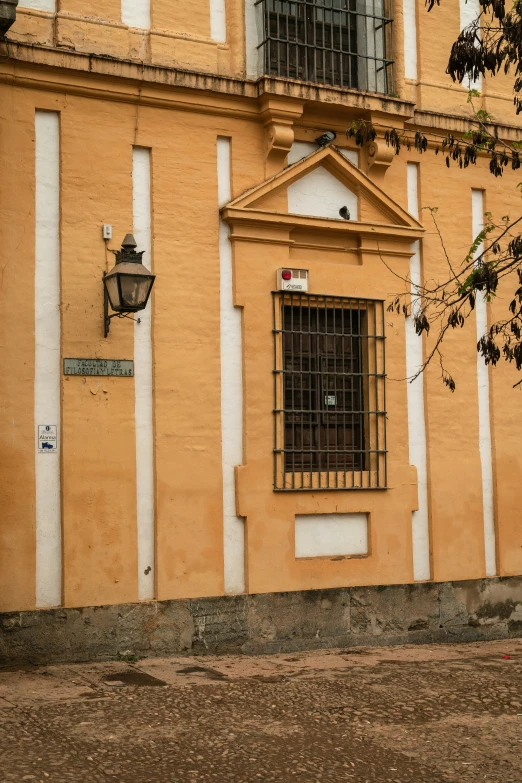 a man walking past a building with bars on the windows