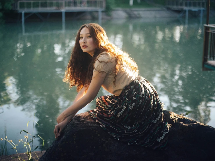 there is a girl that is sitting on a rock