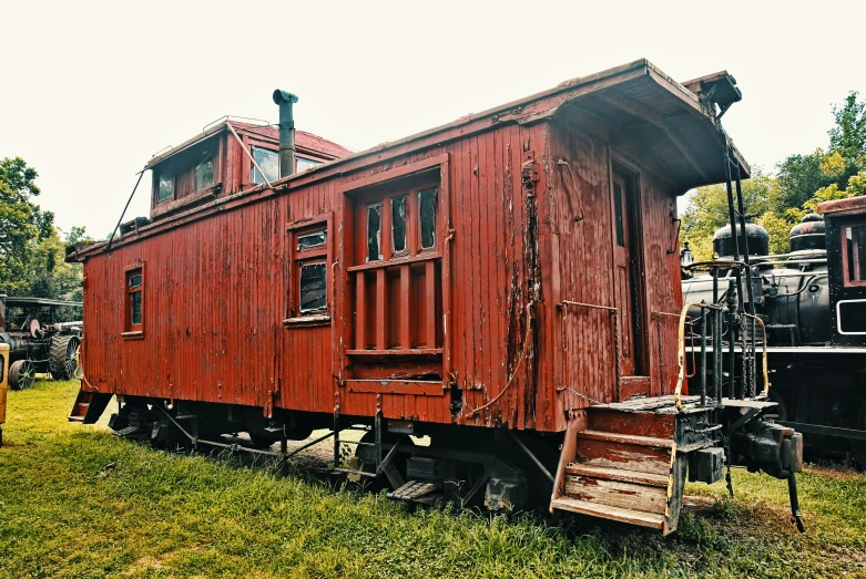 an old fashioned train car parked next to a black train car