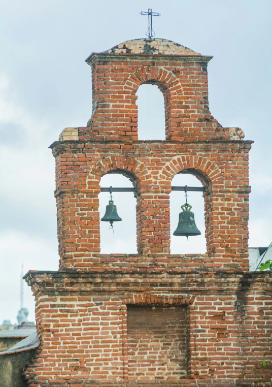 an old brick clock tower with two bells