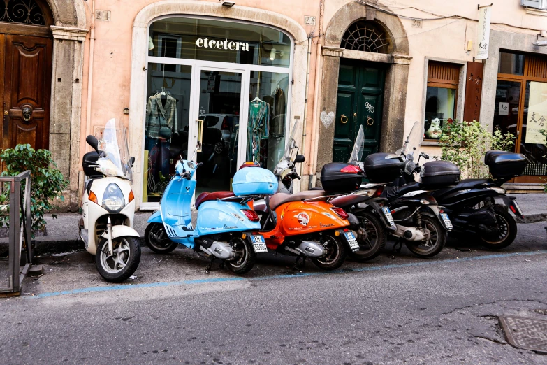 two motorcycles and a motorbike parked in front of a business