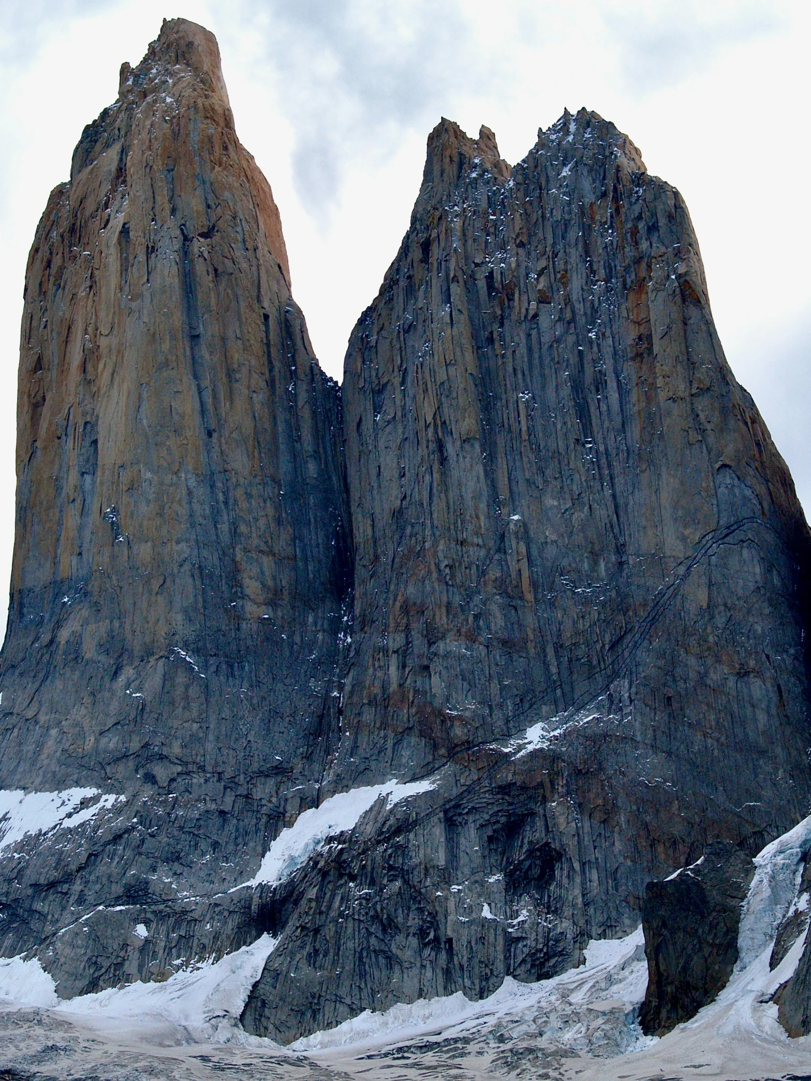 two huge rock mountains standing on a snowy field