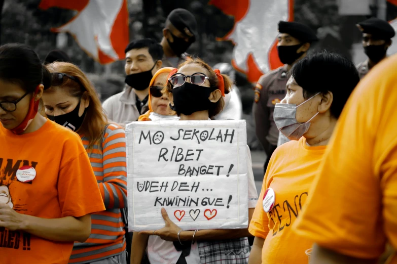 a protest of women from the indonesian people's party against war, with a sign