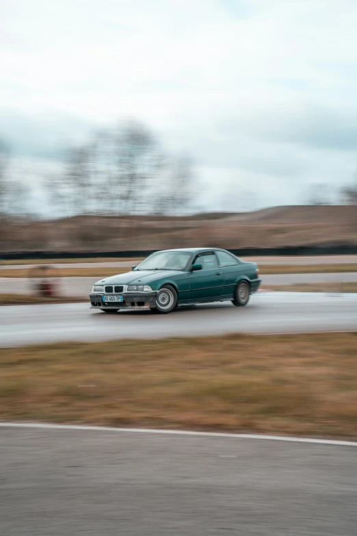 a green sports car driving around a track