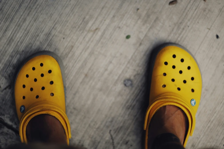 a close up of someone wearing yellow crocs