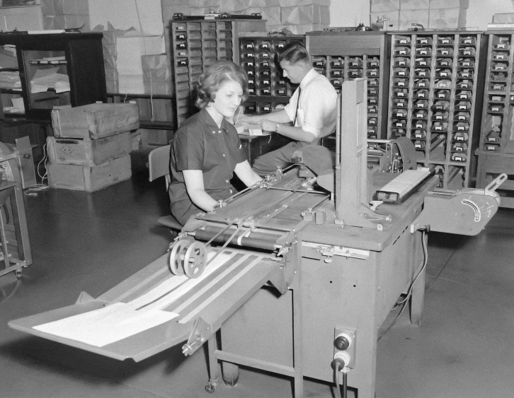 two workers at work in a store with one working on a machine