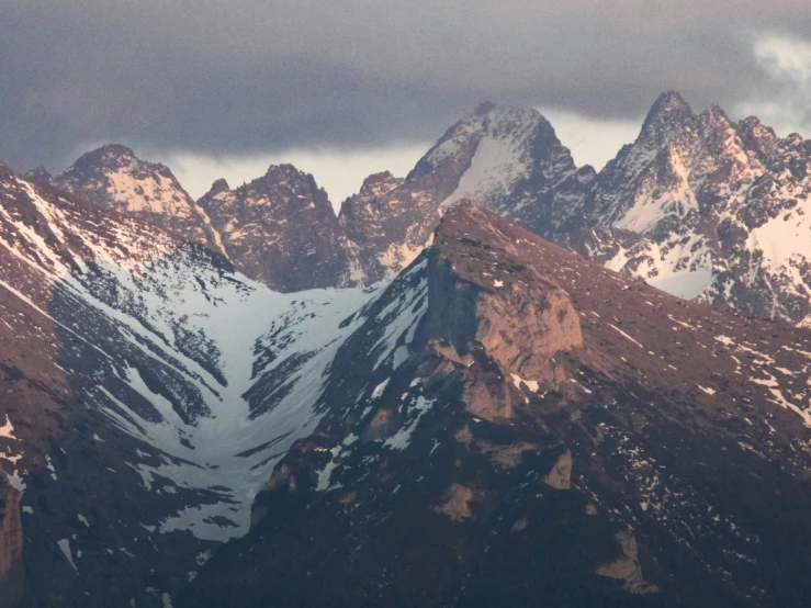 the tops of mountains covered in snow and clouds