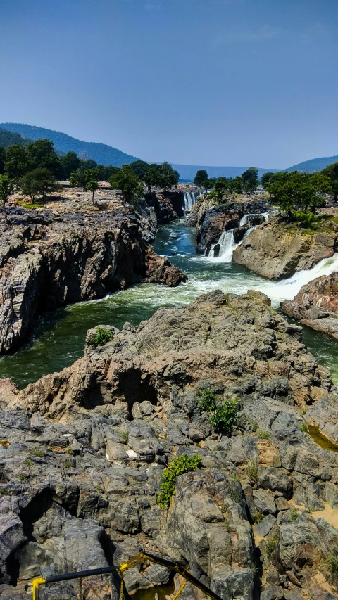 the river in the rocky landscape with a cascade in the distance