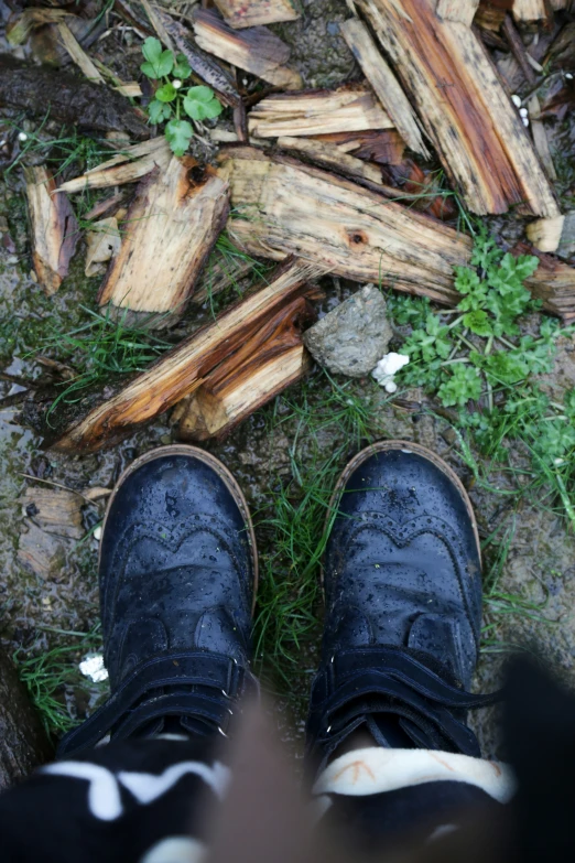 a person with their feet propped up standing in front of some logs