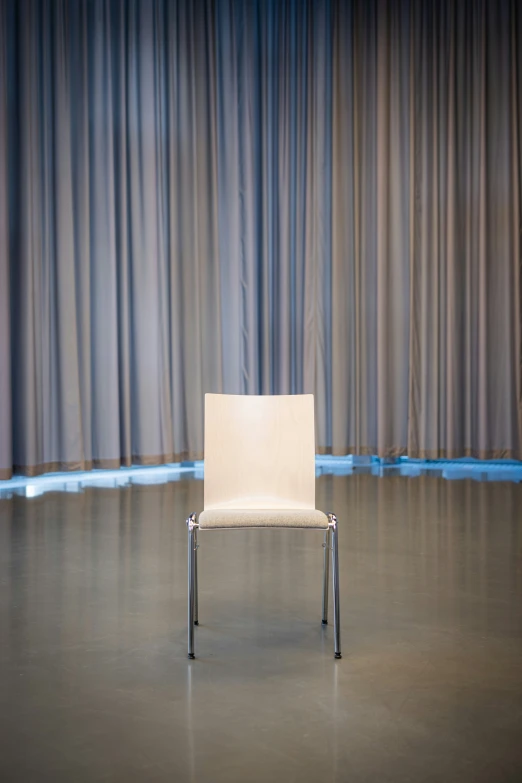 a chair on a stage in front of a curtain