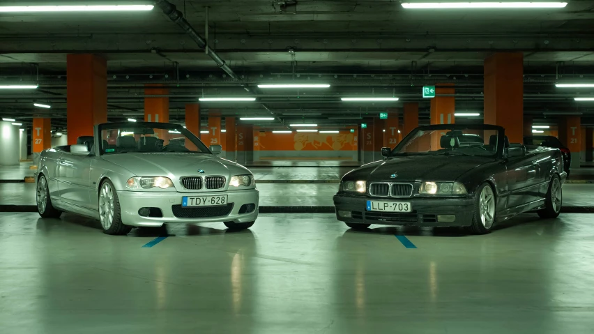 two silver sports cars are in a parking lot