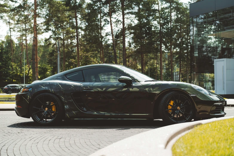 a very clean black car sitting on the side of the street