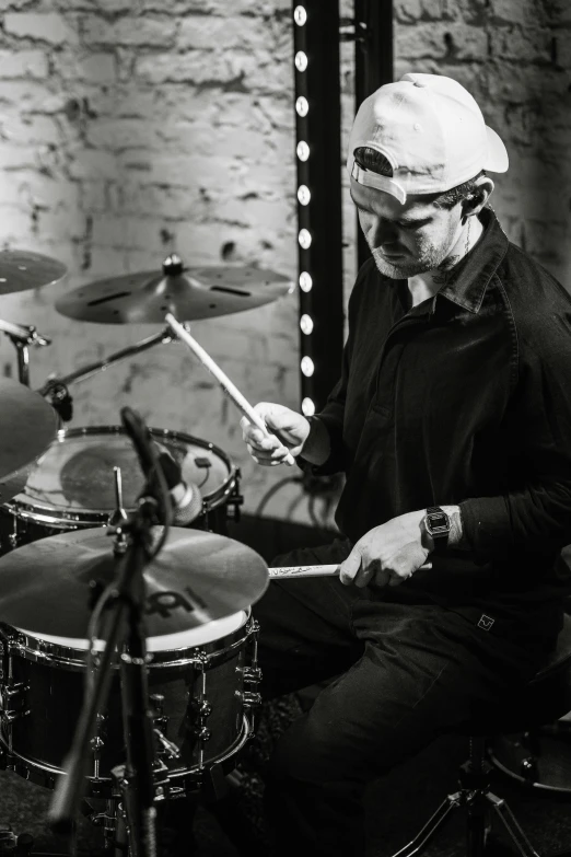 a man wearing headdress playing drums near a mirror