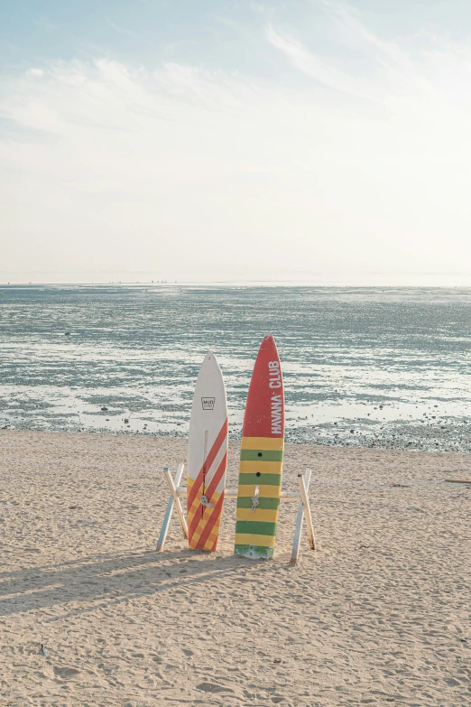 two surfboards that are sitting in the sand