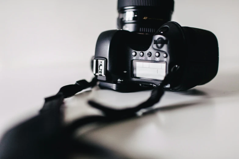 a camera is laying on a table, with a long shadow