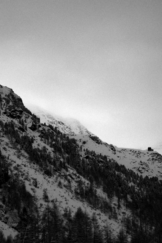 a black and white po of a man on a hill with a snowboard