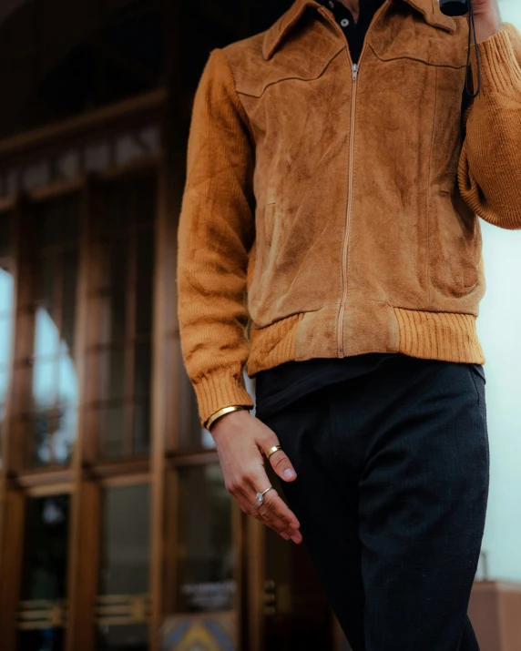 a man wearing a jacket, a sweater, and a hat