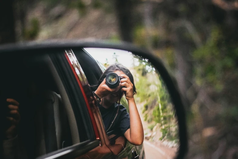 a reflection of a person in a side view mirror