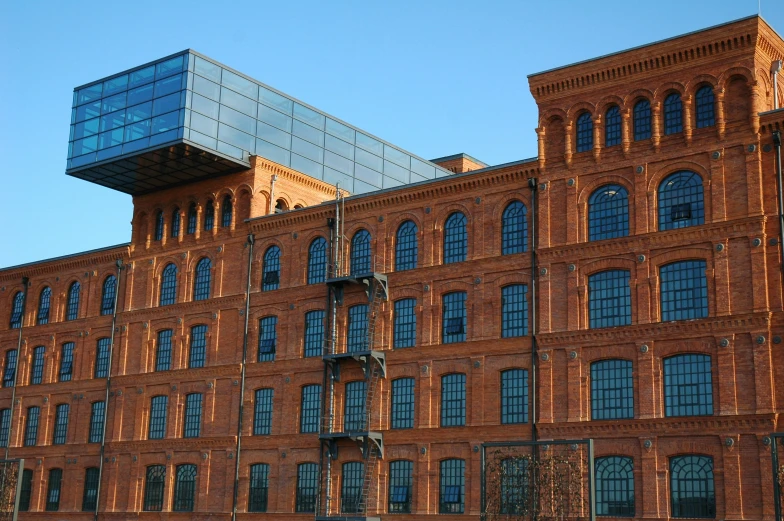 a red brick building with multiple windows and a balconium on top