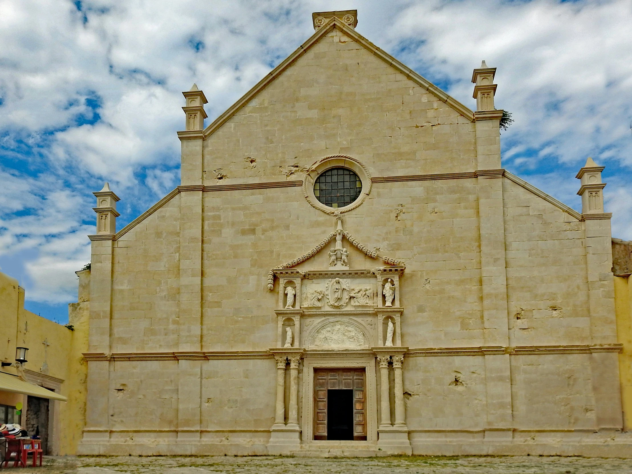 a church with a large stone building and a clock on the side