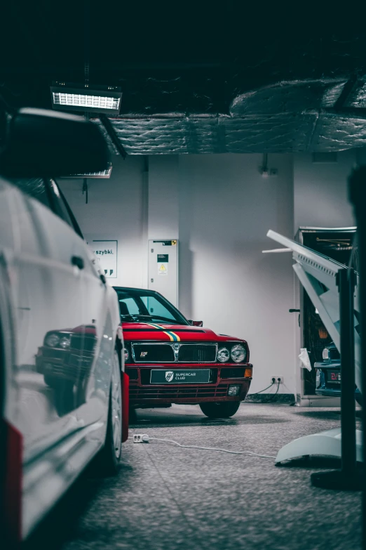 two red cars side by side in a garage