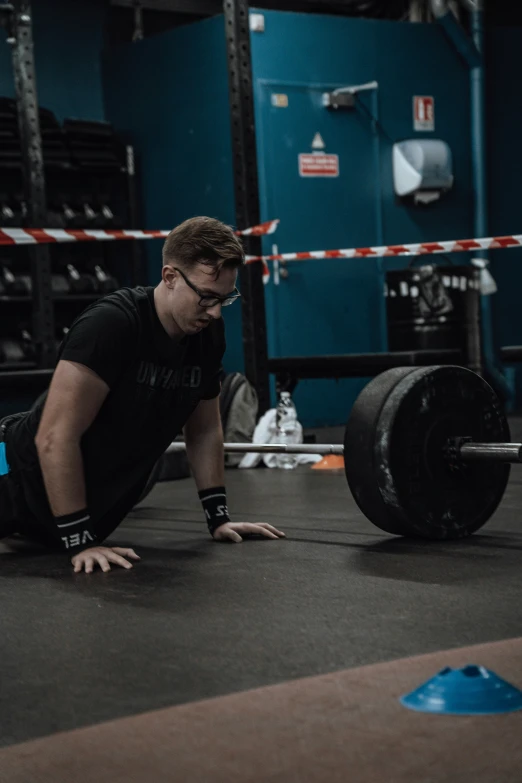 a man standing next to a barbell holding onto a weight bar