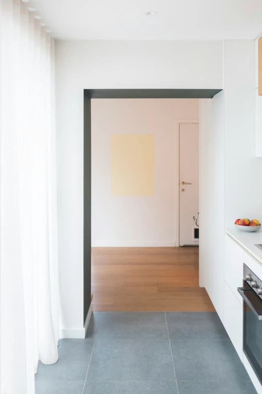 a very long narrow kitchen with all white fixtures