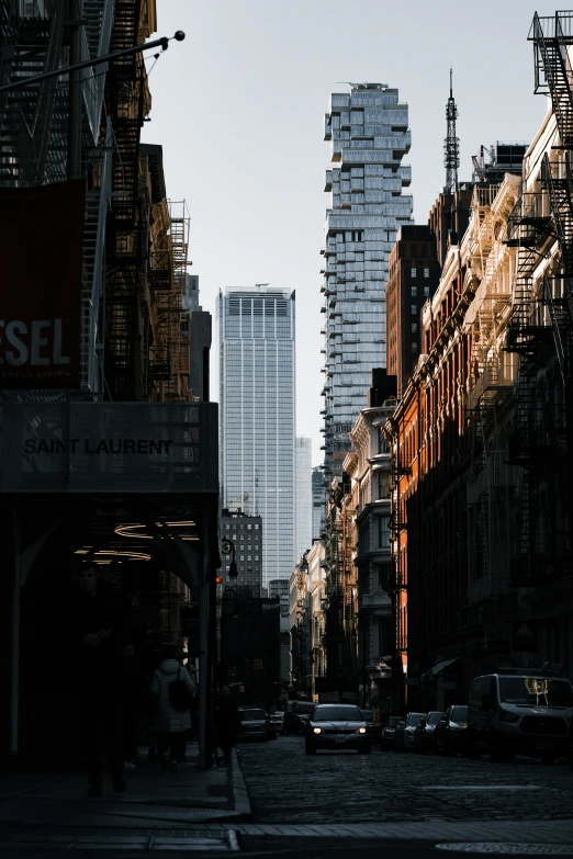 a group of buildings are under construction as pedestrians walk on the street