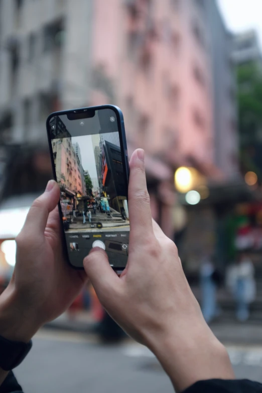 someone holding a cellphone taking a picture of a building