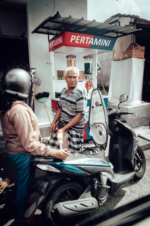 an older man standing next to a parked motorcycle