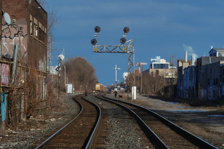 an empty railroad track leading to some buildings