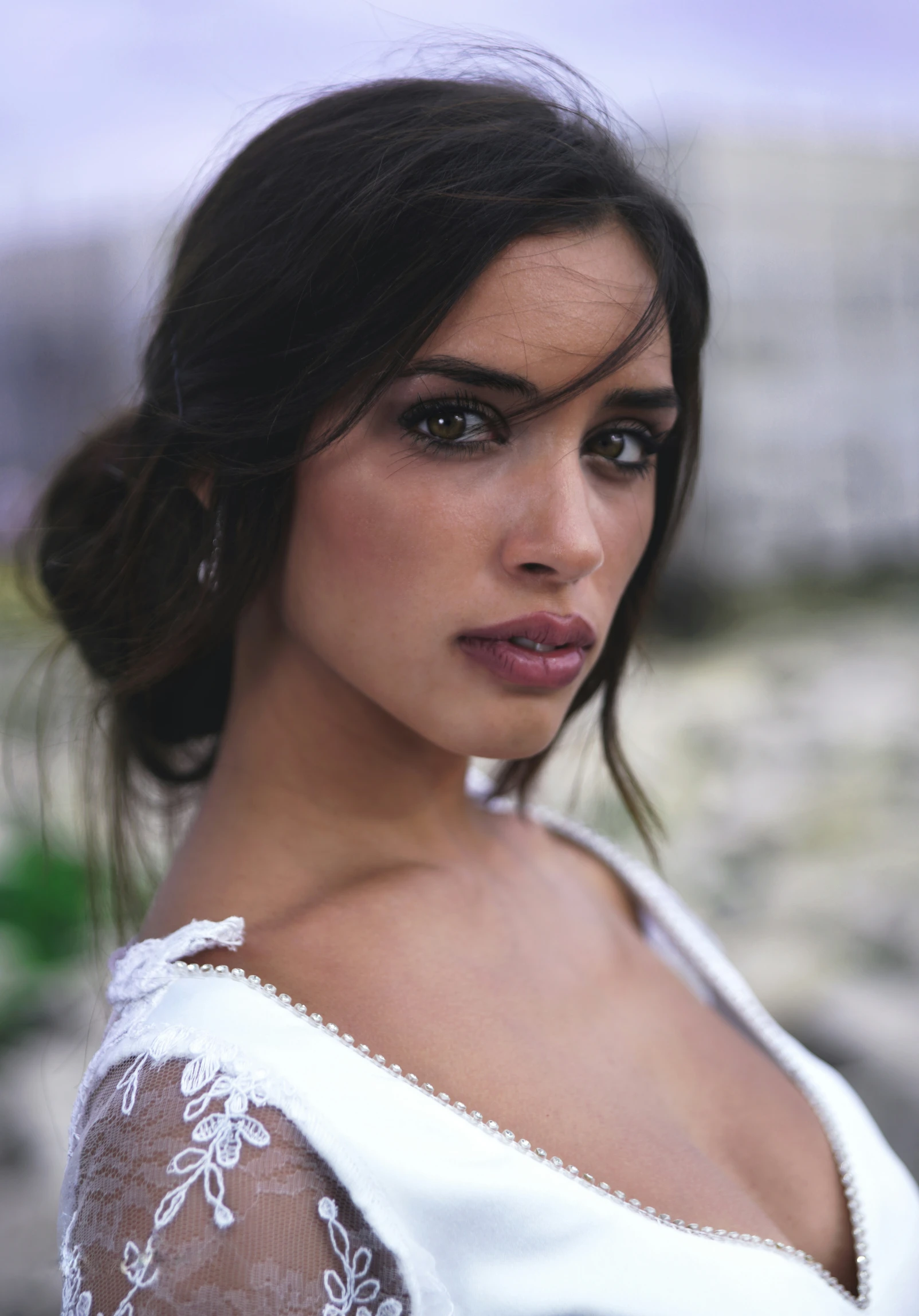 a woman in a white dress and her hair pulled back