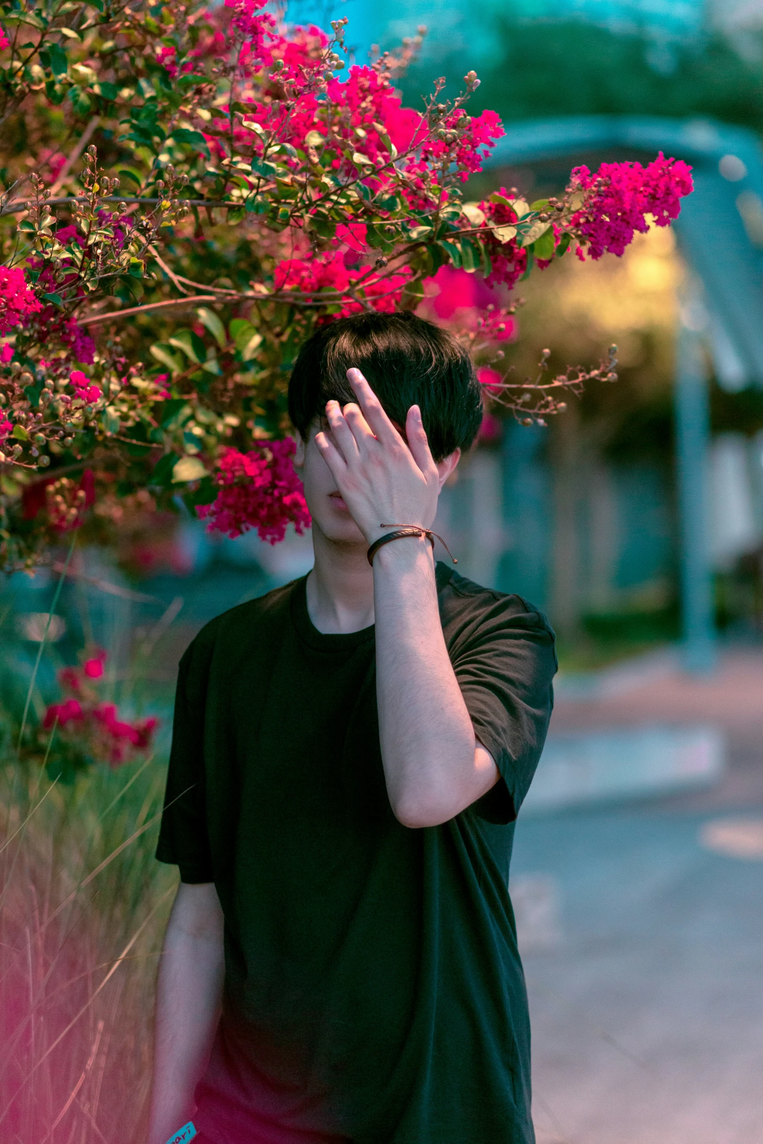 a man standing next to flowers with his hands on his face