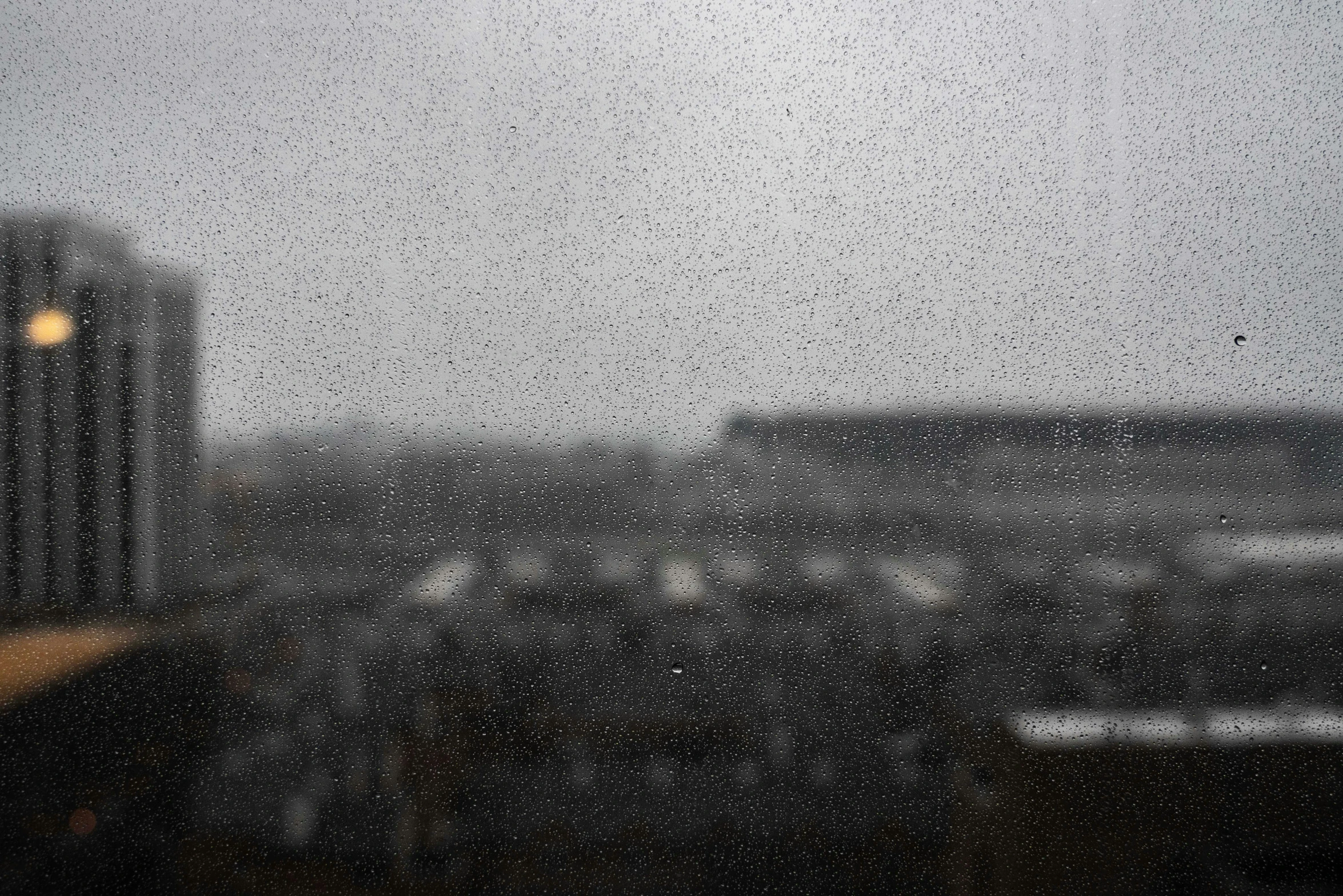 raindrops are seen falling on the glass of a window