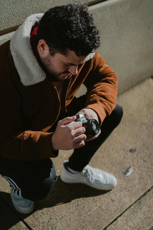 a man taking a po with his camera while sitting on the ground