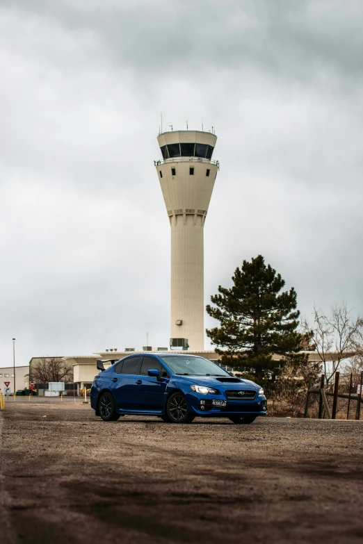 two cars parked near each other in front of an airport control tower